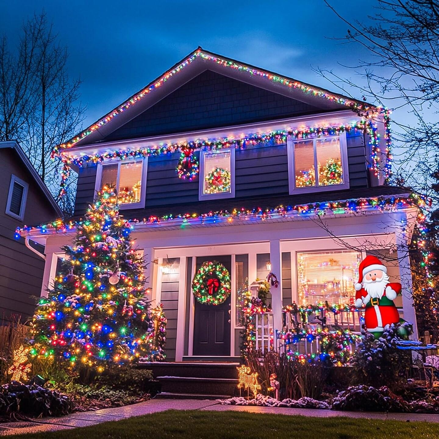 Multicolor residential Christmas light display with wreaths and lawn ornaments